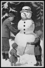 Mann og to barn lager snømann thumbnail
